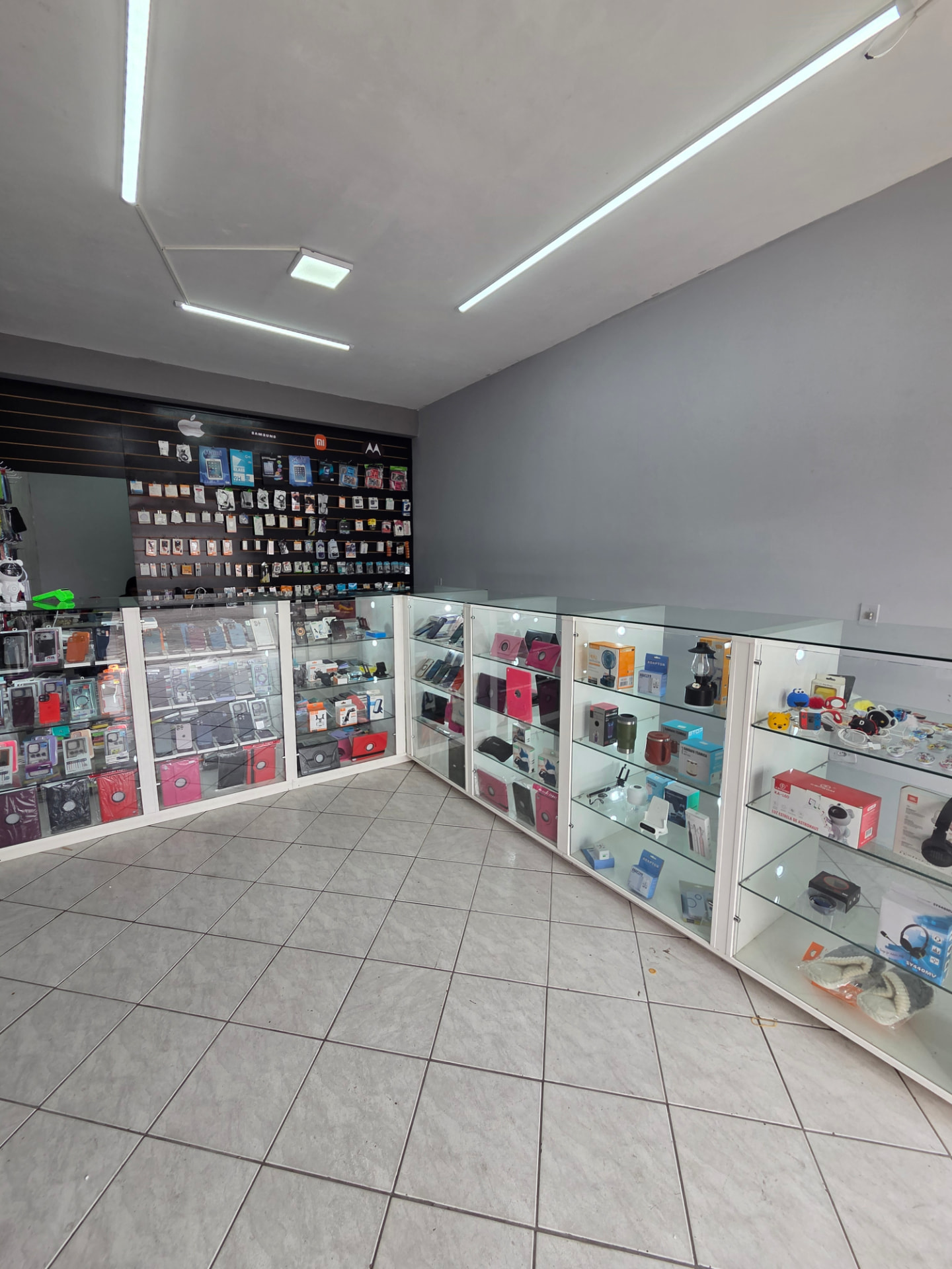 Interior da loja com vitrines de acessórios e eletrônicos